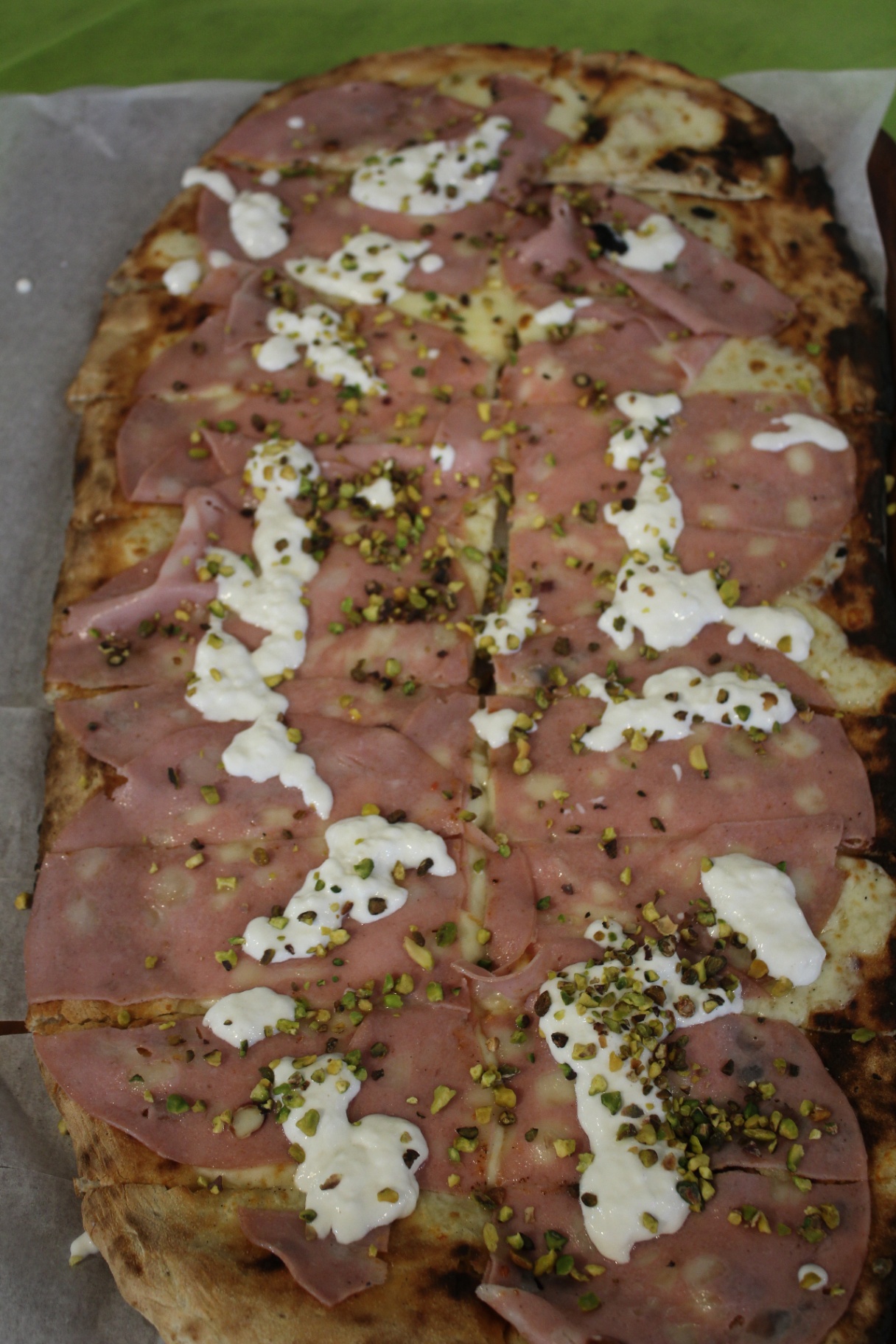 Pizza al forno a legna con mortadella e pistacchio